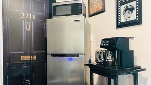 A compact kitchen with a refrigerator, microwave, coffee maker, and toaster on a small table. - Sweet Home Georgia Amour (Peachtree Corners)