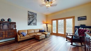 A living room with a sectional sofa, a wooden coffee table, a rocking chair, and a fireplace. - Luxury Condo | Close to Lifts | The Grande 117 (Angel Fire)