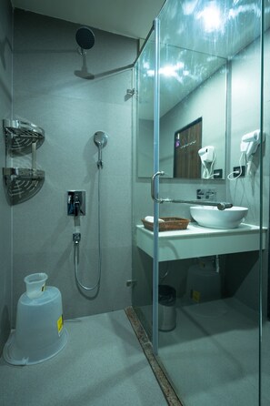 Une salle de bain moderne avec une douche à parois de verre, un lavabo blanc et un miroir.