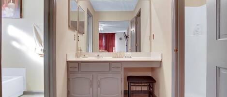 Een badkamer met een wastafel, een spiegel en een lamp erboven.