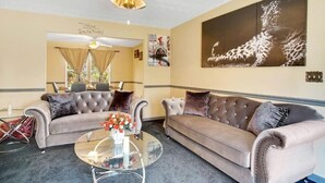A living room with two tufted sofas, a glass coffee table, and a ceiling fan. - Sweet Home Georgia Luxury (Duluth)