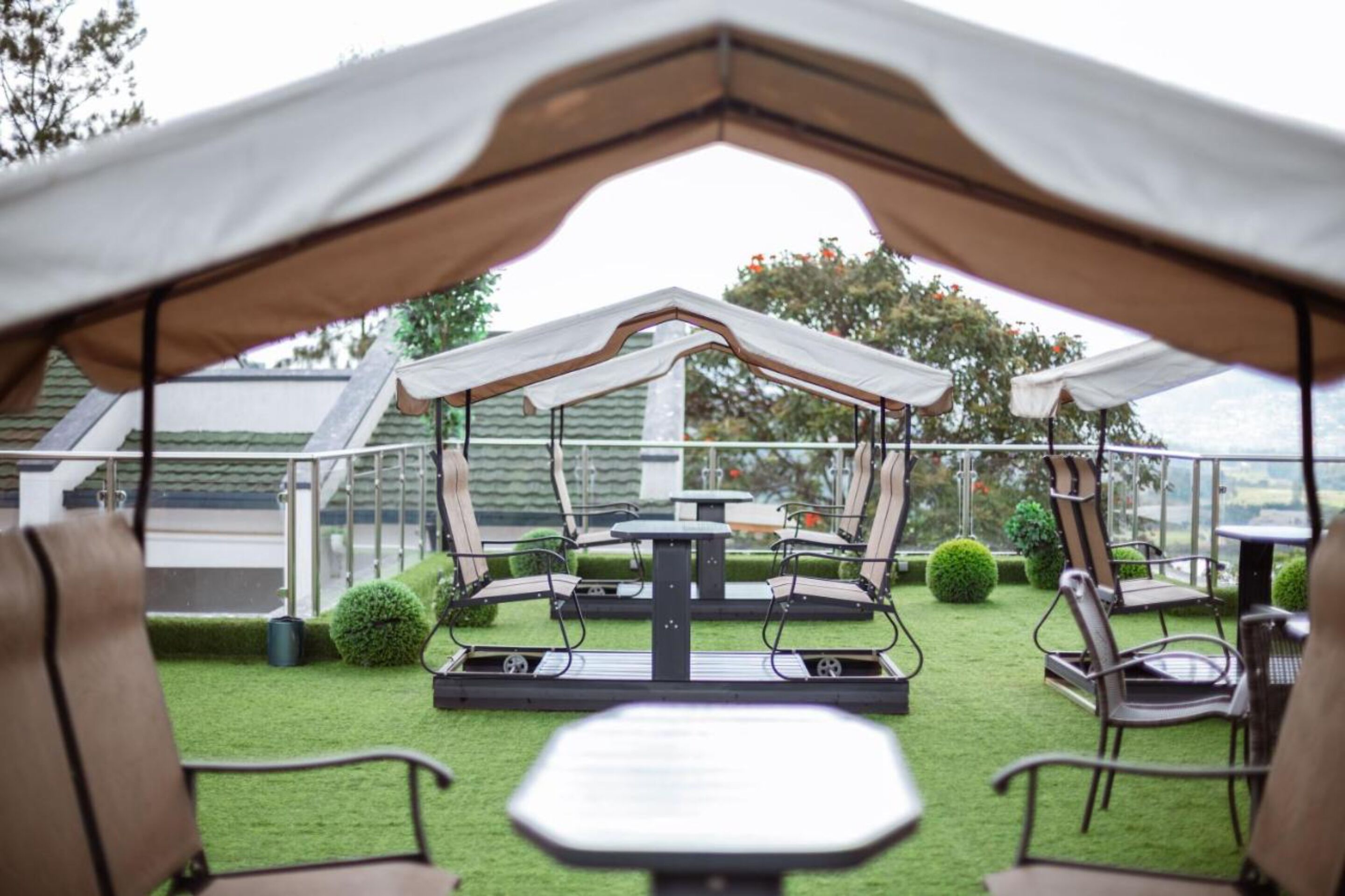 An outdoor patio area with a covered seating arrangement, tables, and chairs.
