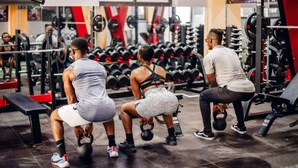 Un gimnasio con equipo de levantamiento de pesas y bancos.
