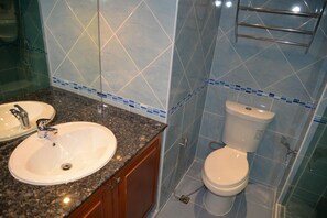A bathroom with a sink, mirror, toilet, and shower. - Jomtien Beach Condo 5th Floor Studio Apartment (Pattaya)