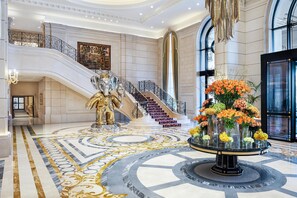 A grand lobby with a marble floor, a staircase, and a decorative fountain. - The Plaza Doha, LXR Hotels & Resorts (Doha)
