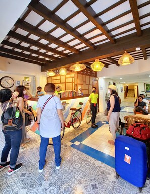 Un vestíbulo con techo de madera, un mostrador de recepción y una bicicleta.