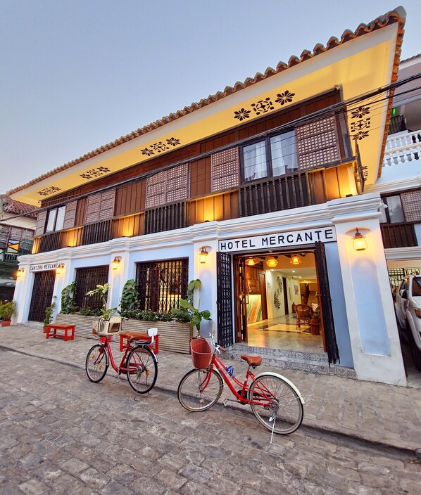 A hotel named "Hotel Mercante" with a traditional architectural style, featuring a balcony and a well-lit entrance. - Hotel Mercante (Vigan)