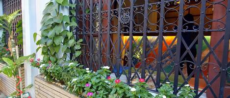 Un banco de madera y una jardinera con diversas plantas y flores.