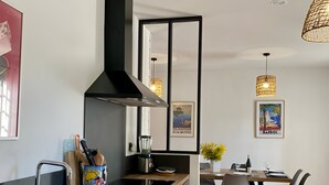Una cocina moderna con una isla central, electrodomésticos de acero inoxidable y un comedor con mesa y sillas.