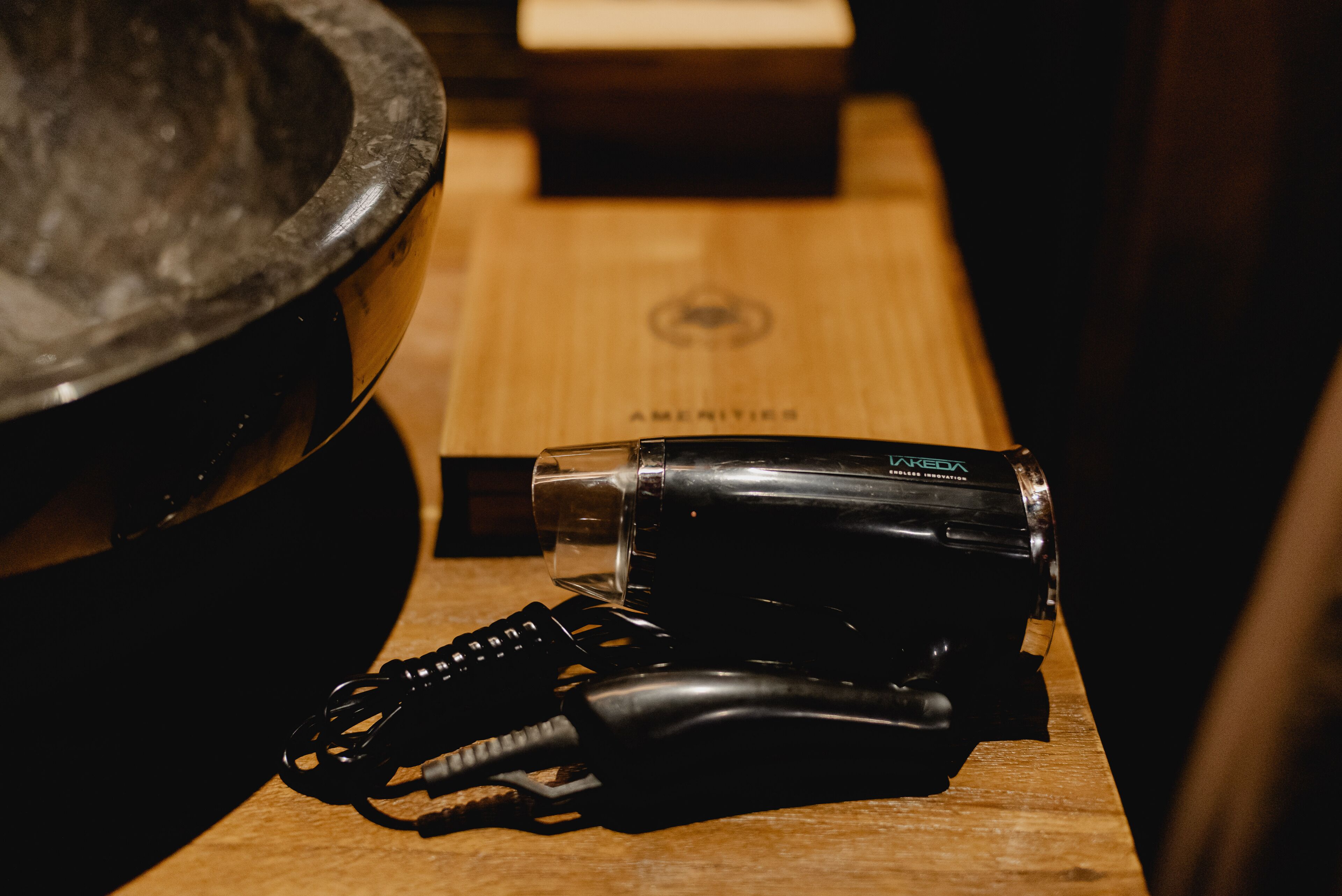 A black camera and a keychain on a wooden surface.