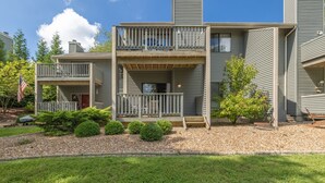 A two-story building with a balcony on the upper level, a small front porch, and a gravel driveway. - The Geneva Studio by Innsbrook Vacations! (Innsbrook)