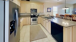 A modern kitchen with a refrigerator, oven, microwave, and dishwasher.