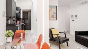 Een modern appartement met keuken, eethoek en woonkamer.