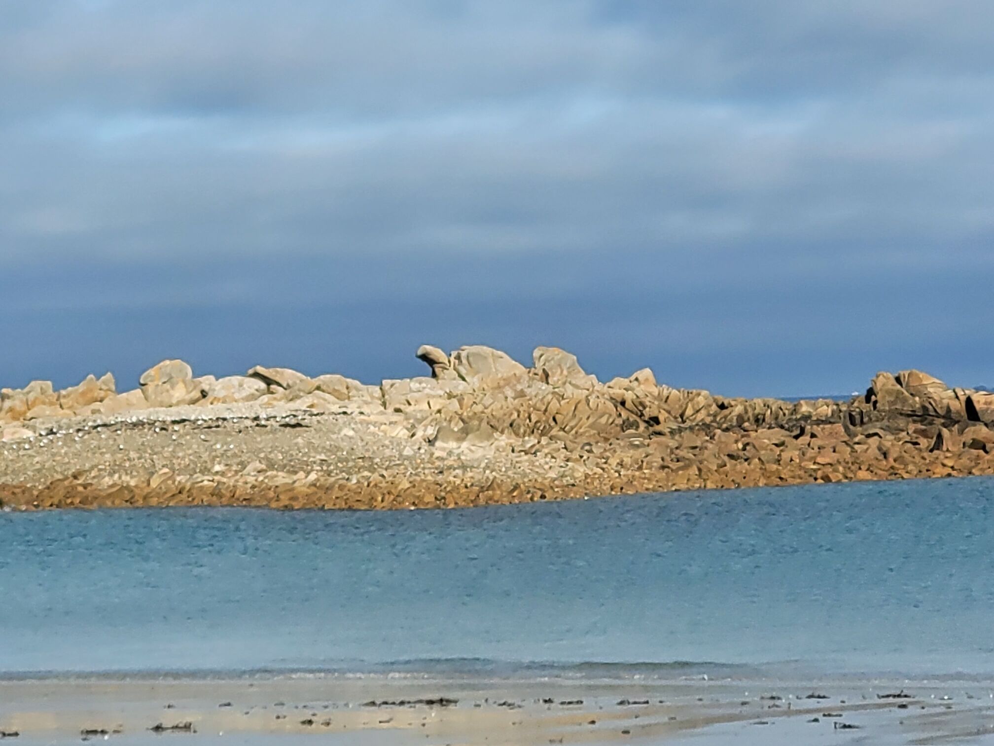 A rocky shoreline with a calm sea.