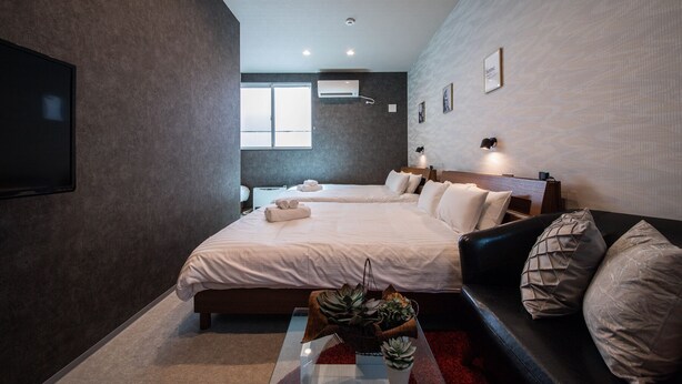 A modern hotel room with a large bed, a sofa, and a TV. - THE PLAZA HOTEL S4W12 (Sapporo)