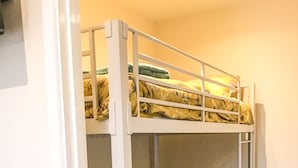 A bunk bed with a floral-patterned bedspread and a green pillow. - Rabbits Warren Sleeps 4 Bike-friendly (Blakeney)