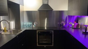 Una cocina moderna con un lavamanos de acero inoxidable, horno empotrado y tostadora.