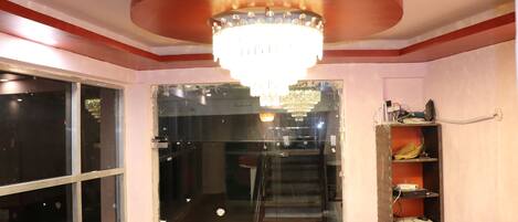 Una habitación de hotel con una araña, una escalera y un estante con objetos.
