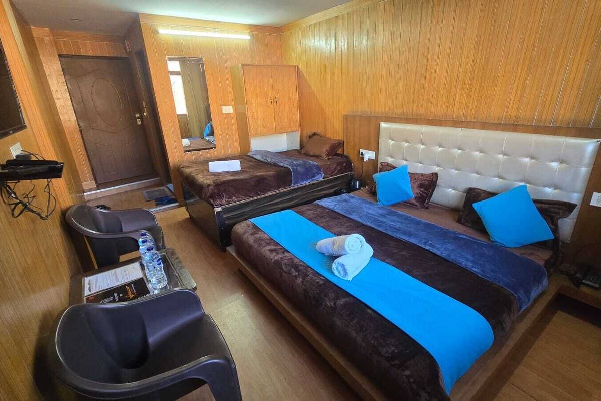 Une chambre d’hôtel avec deux lits, un bureau et une chaise.