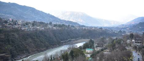 A river flowing through a valley with buildings on the hillsides.