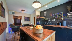 Una cocina moderna con encimera de madera, una cesta de mimbre con pan y una copa de vino.