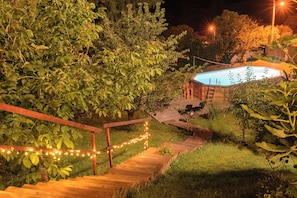 A wooden staircase leading to a pool area surrounded by greenery, with string lights along the steps. - Villa Chill House Keti - Private Pool and Jaccuzzi (Mihovljan)