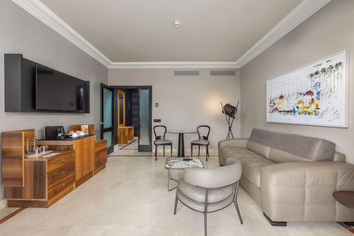 Un salon moderne avec un canapé, une table basse et un téléviseur fixé au mur.