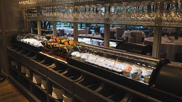 Un área de bufé con varias estaciones de servicio, cristalería y platos.
