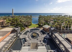 A resort with a central pool, lounge areas, and a view of the ocean. - Unique Club at Lopesan Costa Meloneras Resort (San Bartolomé de Tirajana)
