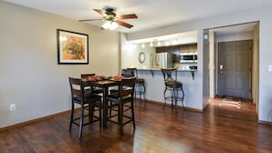 A dining area with a wooden table and chairs, a ceiling fan, and a kitchen in the background. - Matchplay - Resort Amenities W/ Indoor Pool - Comfort Meets Style and Fun! (Branson)