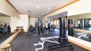 A gym with various exercise equipment, including treadmills, weight machines, and punching bags. - Matchplay - Resort Amenities W/ Indoor Pool - Comfort Meets Style and Fun! (Branson)