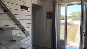 A staircase leading to a door with a 'Welcome' sign, a small painting, and a view of a garden through a glass door. - La chouett'chambre" bed and breakfast (Les Hermites)