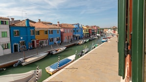 A canal with colorful buildings along the water's edge. - Wondrous Palazzetto 1619 in Magical Burano Island (Burano)