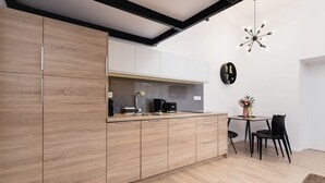 Une cuisine moderne avec des meubles en bois, un plan de travail noir et un coin repas équipé de deux chaises.