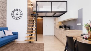 Un appartement moderne avec une chambre en mezzanine, une cuisine et un espace de vie.