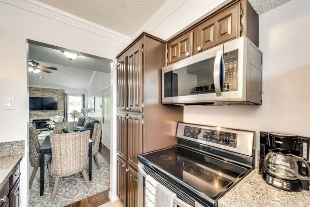 A kitchen with a microwave, oven, and cabinets.