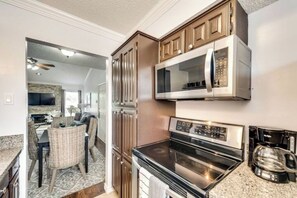 Uma cozinha com micro-ondas, forno e armários.
