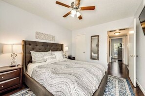 A bedroom with a large bed, a ceiling fan, a nightstand, and a bedside table. - I22 - Apt|Yard|11mi to Fair Park|Sleeps 4 (Irving)