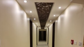 A long, narrow hallway with tiled floors and recessed lighting. - Rendezvous hotel petra (Wadi Musa)