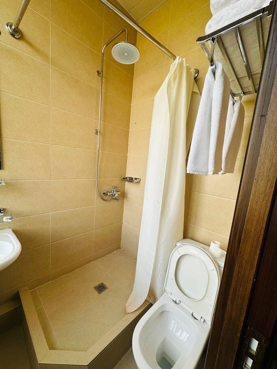 A small bathroom with a shower, toilet, and a sink.