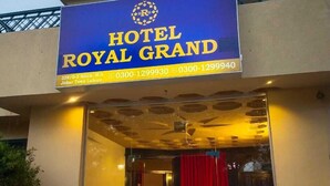The exterior of Hotel Royal Grand with a blue signboard displaying the hotel's name and contact information. - Hotel Royal Grand (Mekhtar)