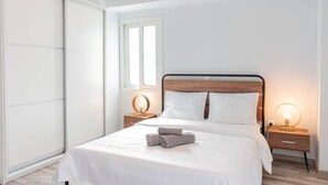 A modern bedroom with a large bed, a window, a bedside table with a lamp, and a sliding door. - Friendly Accommodation-GTD33701 (Athens)