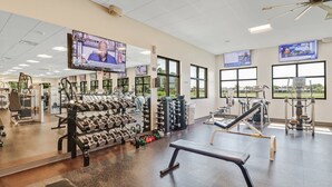 A gym with various exercise equipment, including dumbbells, weight machines, and cardio machines. - Heron's Glen Beautiful Beachy Home in Gated Golf Community Home (North Fort Myers)