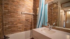 Un baño con bañera, lavamanos y ducha.