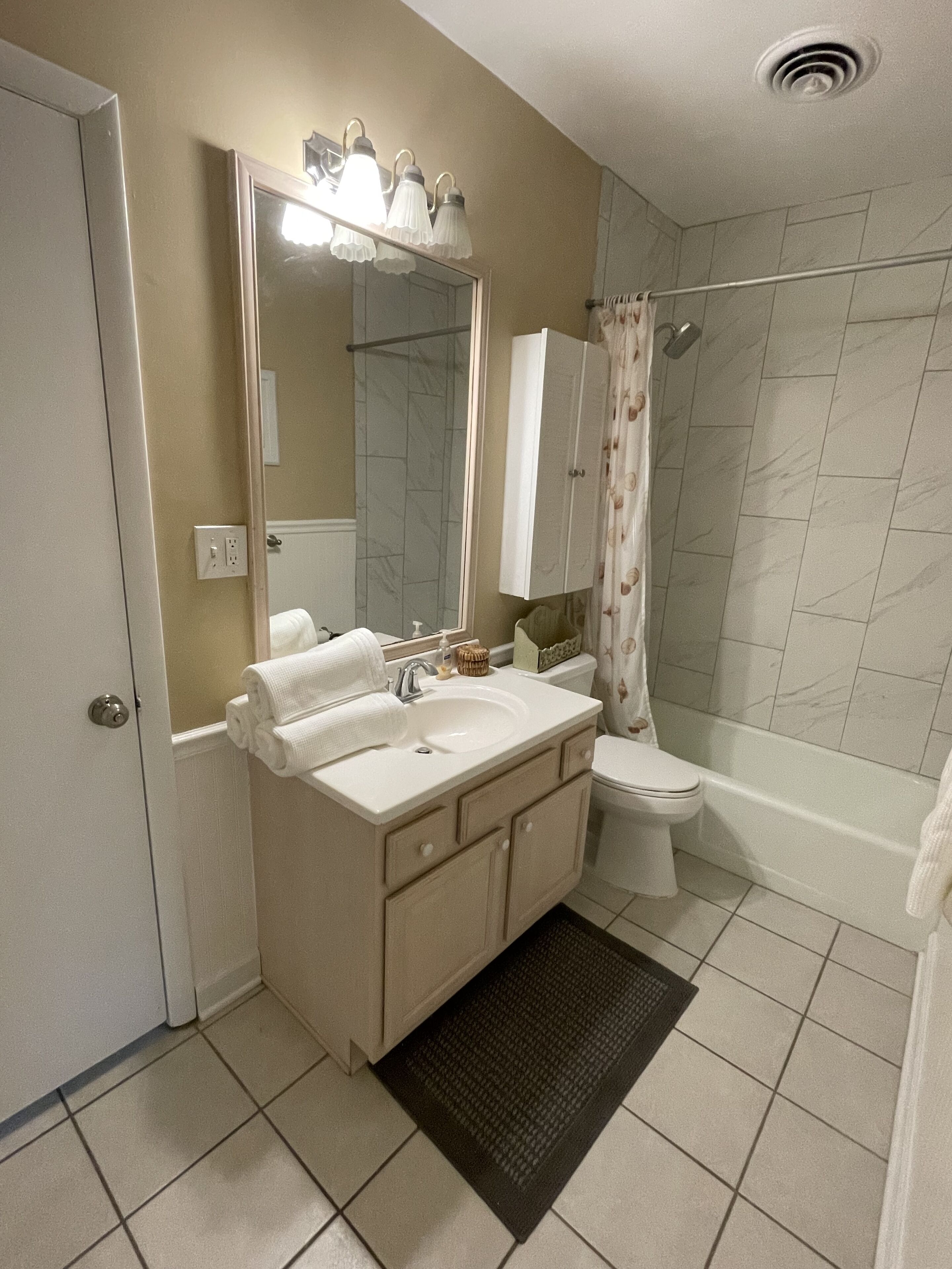 A bathroom with a double sink vanity, a toilet, a shower with a glass door, and a bathtub.