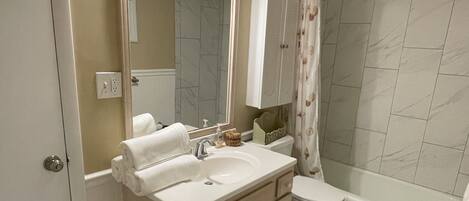 A bathroom with a double sink vanity, a toilet, a shower with a glass door, and a bathtub.