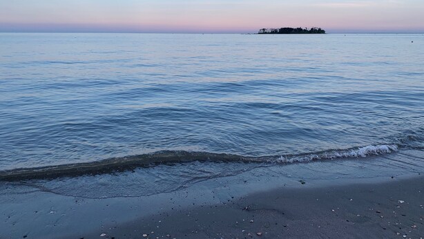 A beach with calm waters and a distant island. - Renovated Milford Beach home by Charles Island/Silver Sands Pk (Milford)