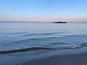 Ein Strand mit ruhigem Wasser und einer fernen Insel.