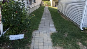 A narrow paved pathway between two buildings with a sign indicating '718 East Broadway'. - Renovated Milford Beach home by Charles Island/Silver Sands Pk (Milford)