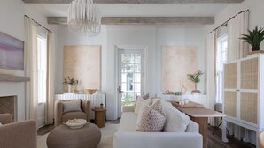 A spacious living room with a fireplace, a dining area, and a large window with curtains.